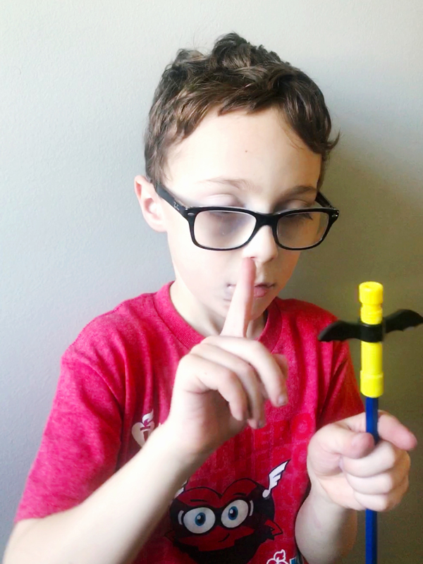 How Fidgeting Improves Focus and Self-Regulation Young boy holds the Bat Wingamajig fidget in one hand and spins the wings with his other hand