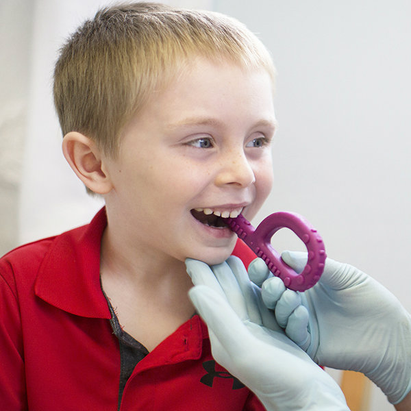 Using Chew Tools in Oral Motor / Feeding Therapy A child bites down on the ARK Textured Grabber P shaped chew tool in between the pre-molars to build jaw strength and oral motor skills