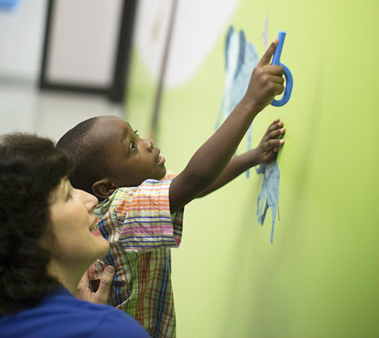 Using the Grabber to Assist Pointing / Joint Attention A child points to something using the Grabber during a speech therapy session