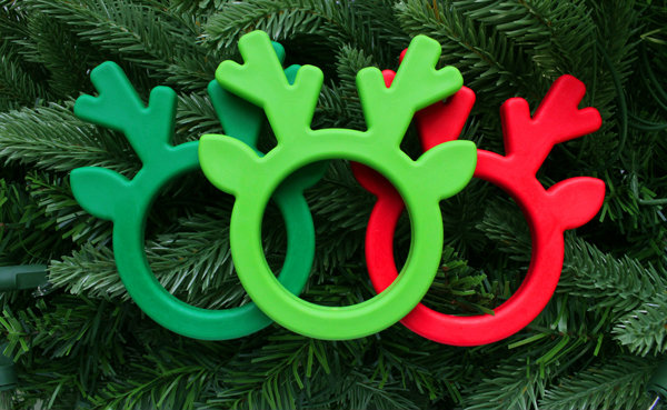 Oral Sensory Stocking Stuffer Ideas The forest green, lime green, and red ARK reindeer chews on a backdrop of Christmas tree branches