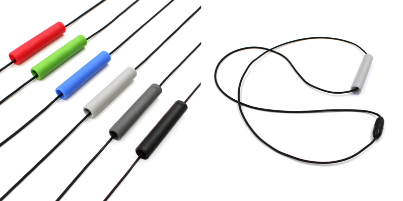 On the left: a row of various colors of the Chewlinder necklace.  On the right: a view of the light grey pendant from the side.