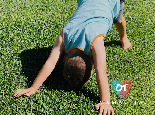 What Is a Sensory Diet? A young boy stands on his hands and feet outside in a yard for vestibular input