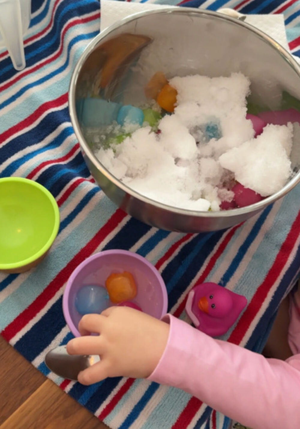 Key Tips to Help Kids Regulate through the Holidays A child's hand plays in an ice themed sensory bin