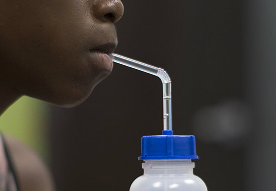 A teenager sips from the Cip-Kup adaptive straw drinking cup
