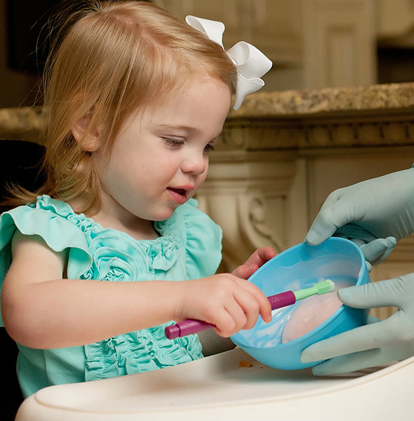 Oral Sensory Exercises for Toddlers & Young Children A therapist supervises a girl exploring food with the Z-Vibe